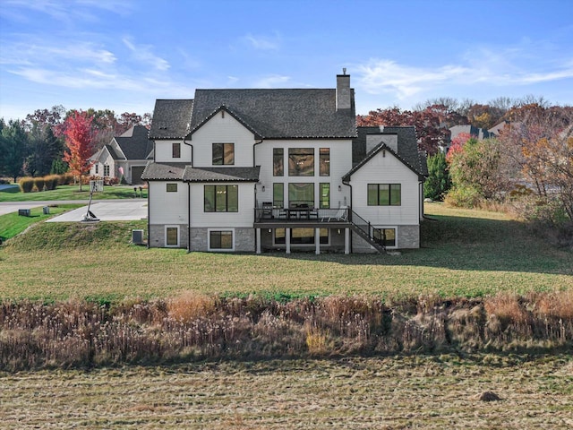 rear view of house featuring a lawn and a wooden deck