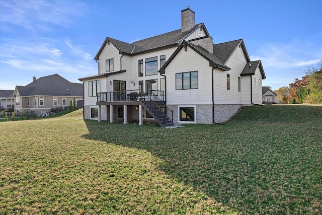 back of property with a deck and a lawn