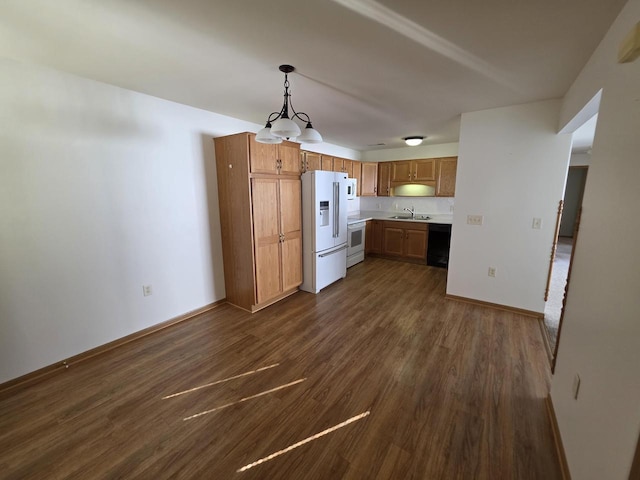 kitchen with sink, decorative light fixtures, white appliances, and dark hardwood / wood-style flooring