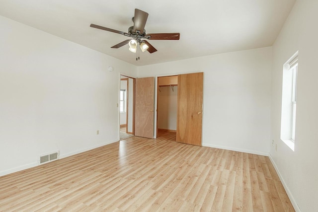 unfurnished bedroom with baseboards, visible vents, a closet, and light wood-style flooring