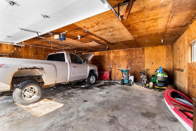 garage featuring wooden walls and a garage door opener