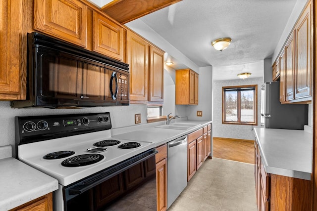 kitchen featuring appliances with stainless steel finishes, sink, and a textured ceiling