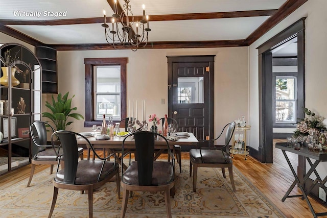 dining room featuring beam ceiling, light hardwood / wood-style flooring, and an inviting chandelier