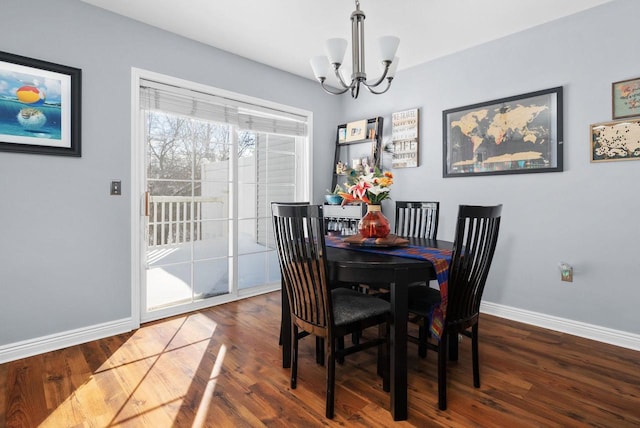 dining space with dark wood-type flooring and a chandelier