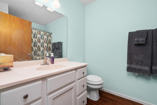 bathroom featuring toilet, hardwood / wood-style flooring, and vanity