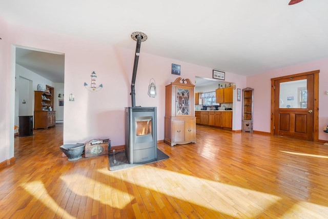 living room featuring light wood-type flooring and a wood stove