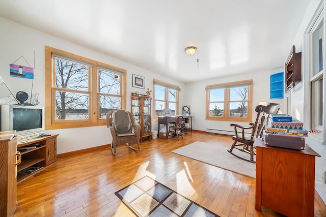 living area featuring light wood-type flooring and baseboard heating