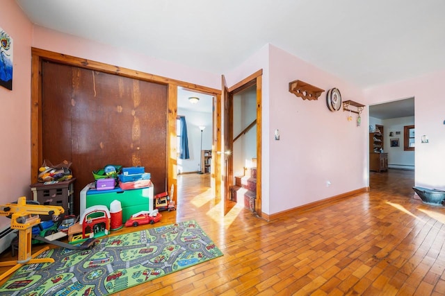 playroom with baseboard heating and hardwood / wood-style floors