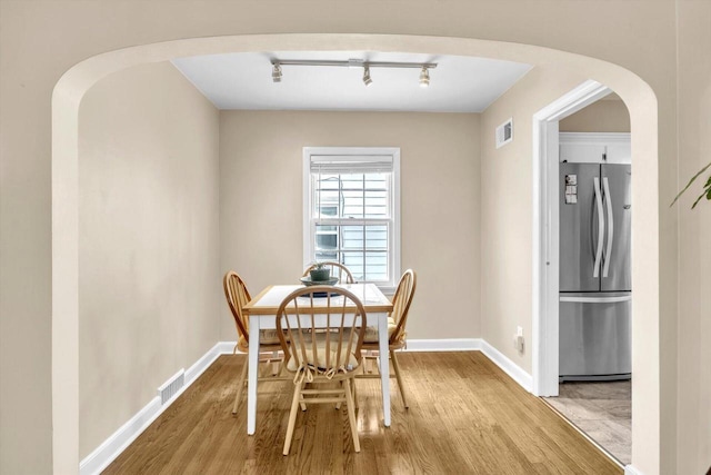 dining space featuring light hardwood / wood-style floors and track lighting