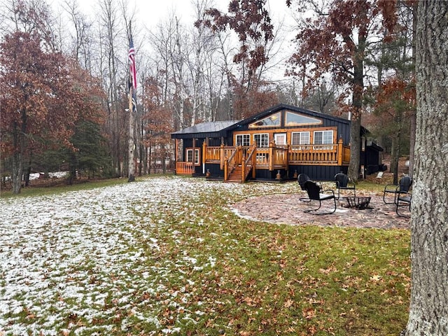 back of house with a patio area, a lawn, a wooden deck, and an outdoor fire pit