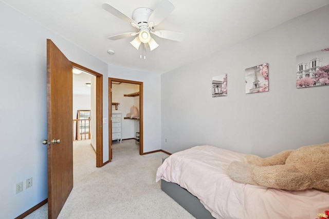 bedroom featuring ceiling fan, light colored carpet, and a spacious closet