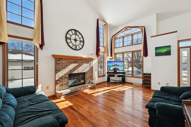 living room with hardwood / wood-style floors, high vaulted ceiling, and a wealth of natural light