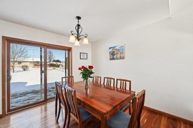 dining space featuring hardwood / wood-style flooring and a notable chandelier