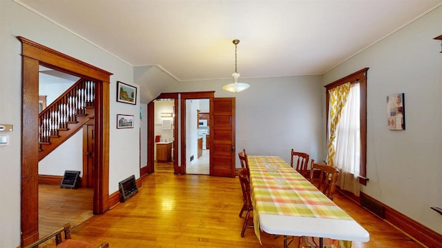 dining space with hardwood / wood-style floors and crown molding