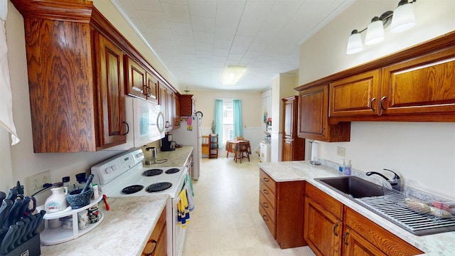 kitchen with white appliances, sink, and light stone countertops