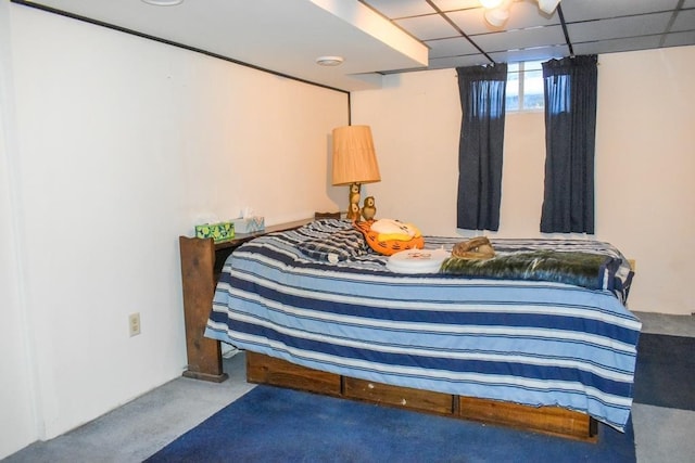 bedroom with a drop ceiling and carpet