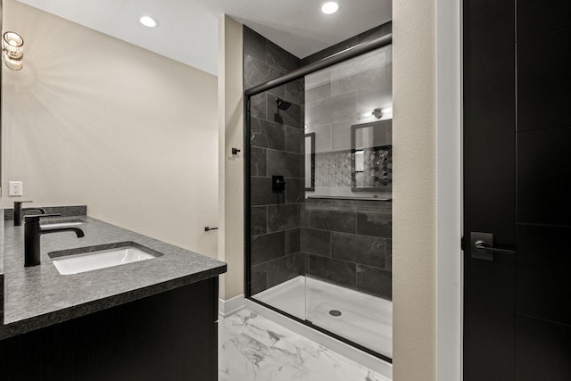 bathroom with a shower with shower door and vanity