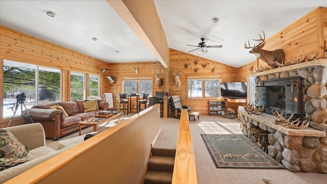 living area with wood walls, light carpet, a wealth of natural light, and vaulted ceiling