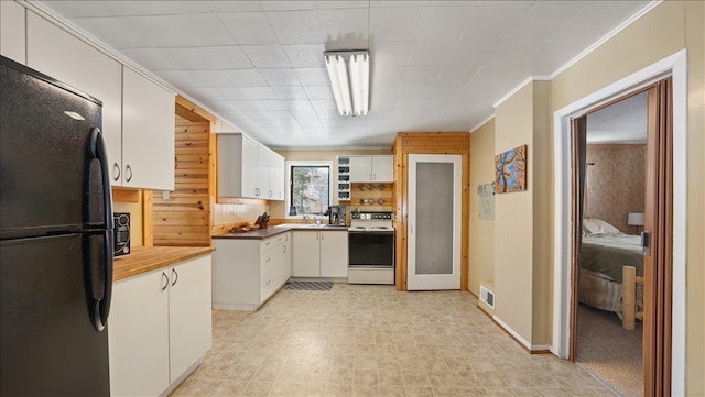 kitchen featuring freestanding refrigerator, visible vents, white electric range, and white cabinetry