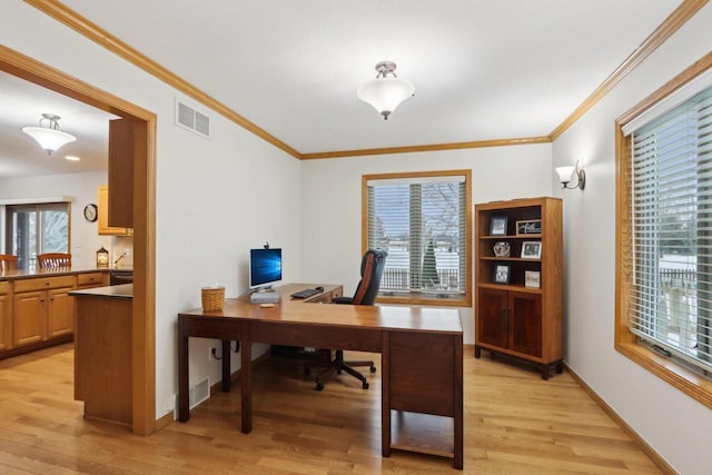 office featuring light wood-style floors, baseboards, visible vents, and ornamental molding