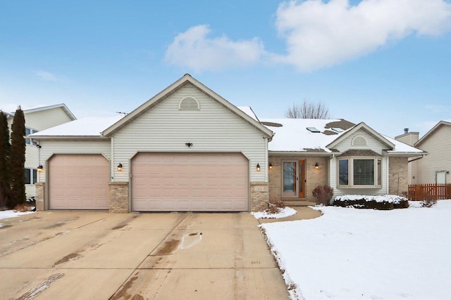 single story home featuring a garage, driveway, and brick siding