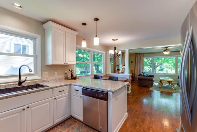 kitchen featuring kitchen peninsula, white cabinetry, stainless steel appliances, and sink