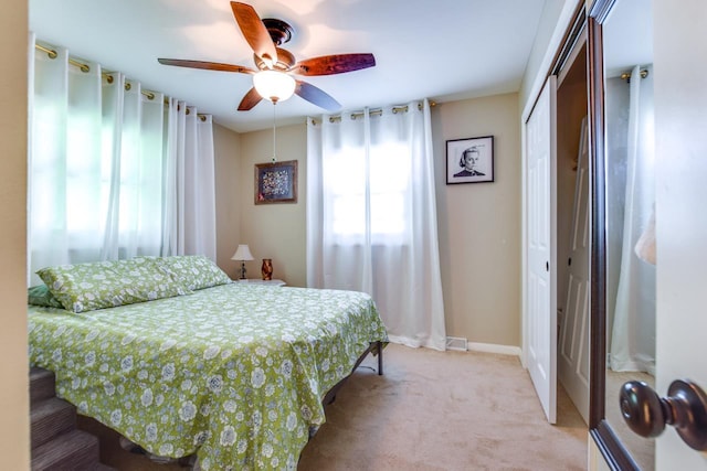 carpeted bedroom featuring a closet and ceiling fan