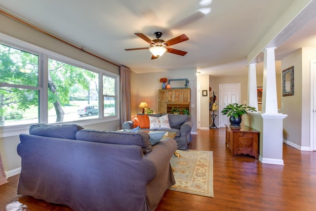 living room with ceiling fan, dark wood-type flooring, and ornate columns