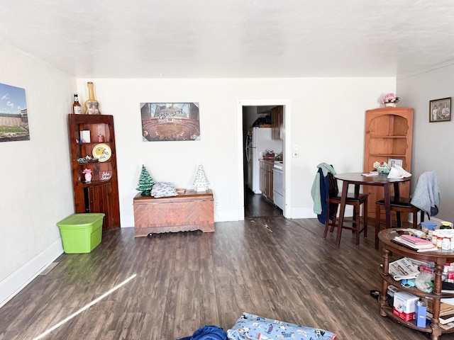 living area with baseboards and wood finished floors