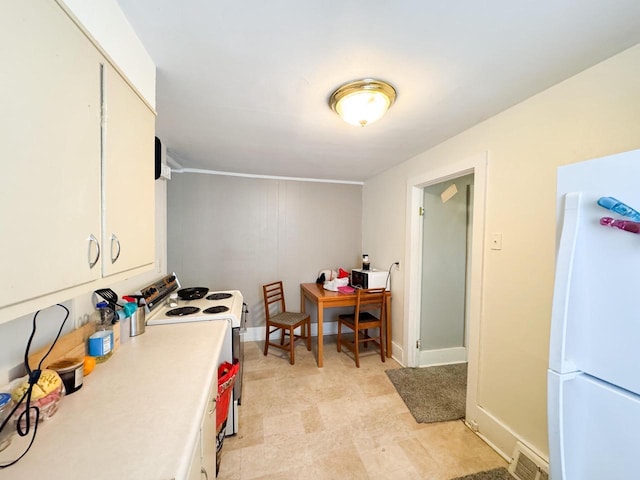 kitchen featuring white appliances, light countertops, visible vents, and white cabinets