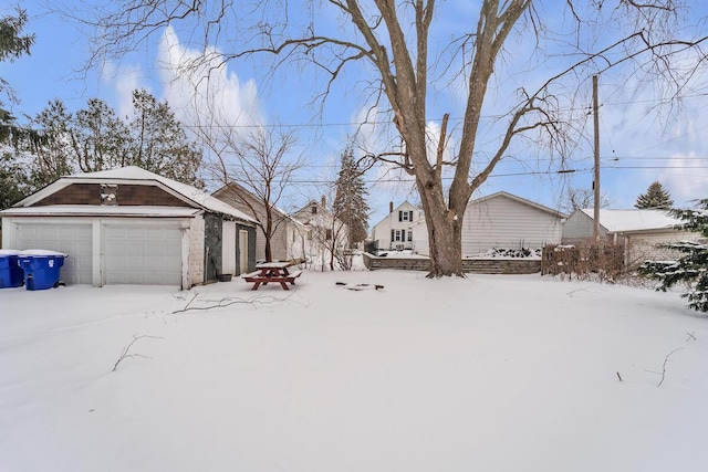 yard layered in snow featuring a garage