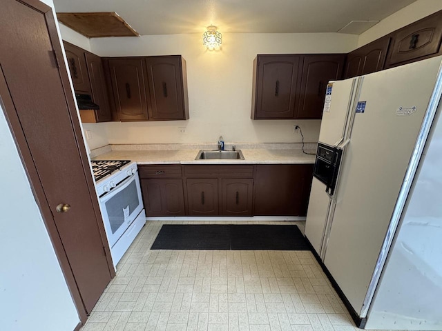 kitchen featuring white appliances, dark brown cabinets, and sink