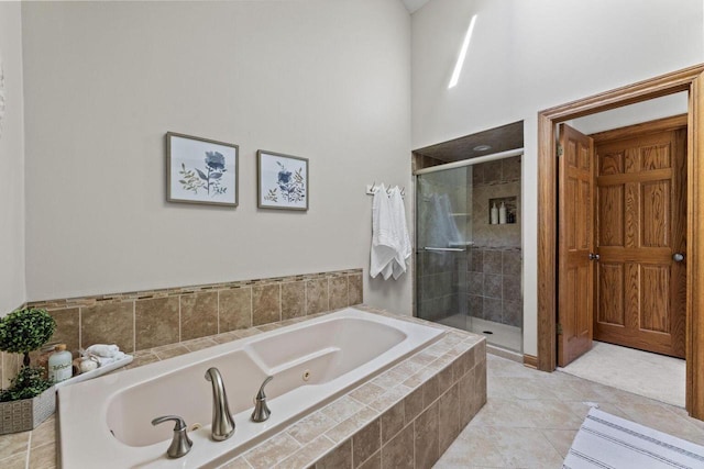 bathroom featuring tile patterned flooring and shower with separate bathtub