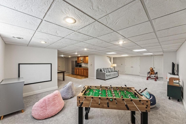 recreation room featuring a paneled ceiling and carpet