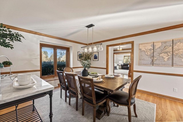 dining space featuring light hardwood / wood-style floors and ornamental molding