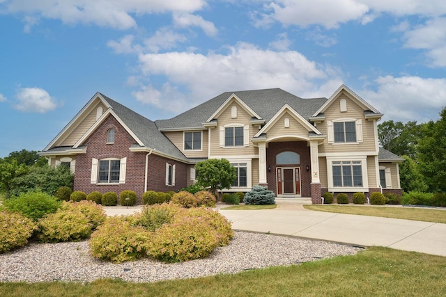 view of front of home with driveway and brick siding