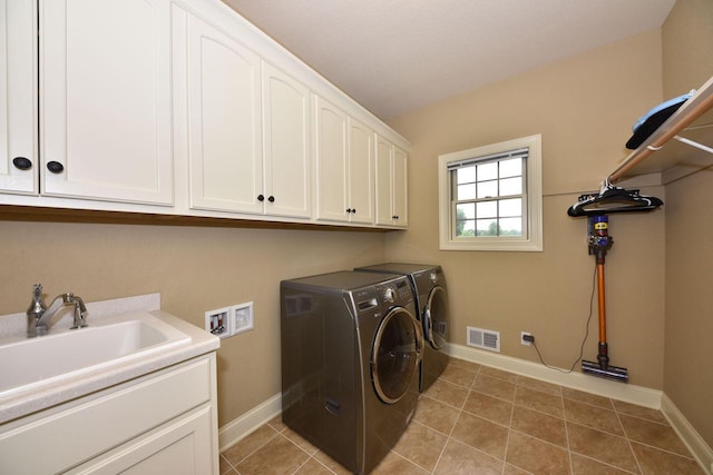 laundry area featuring cabinet space, visible vents, a sink, tile patterned flooring, and baseboards