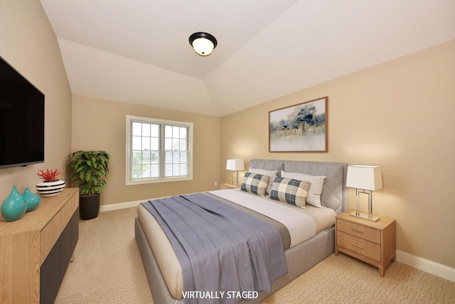 bedroom featuring baseboards, lofted ceiling, and light colored carpet