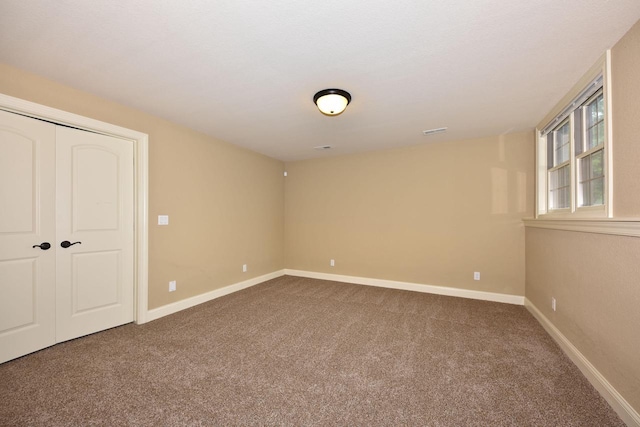 empty room featuring carpet flooring and baseboards