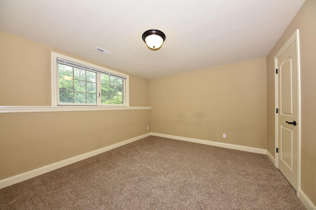 spare room with carpet, visible vents, and baseboards