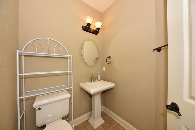 bathroom with tile patterned flooring, toilet, and baseboards