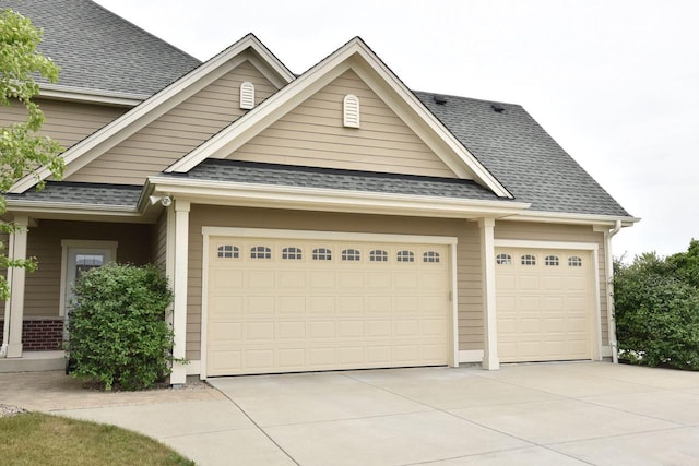 view of front of house with a garage, concrete driveway, brick siding, and roof with shingles