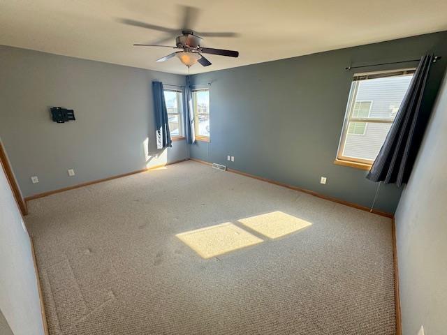 spare room featuring carpet and ceiling fan