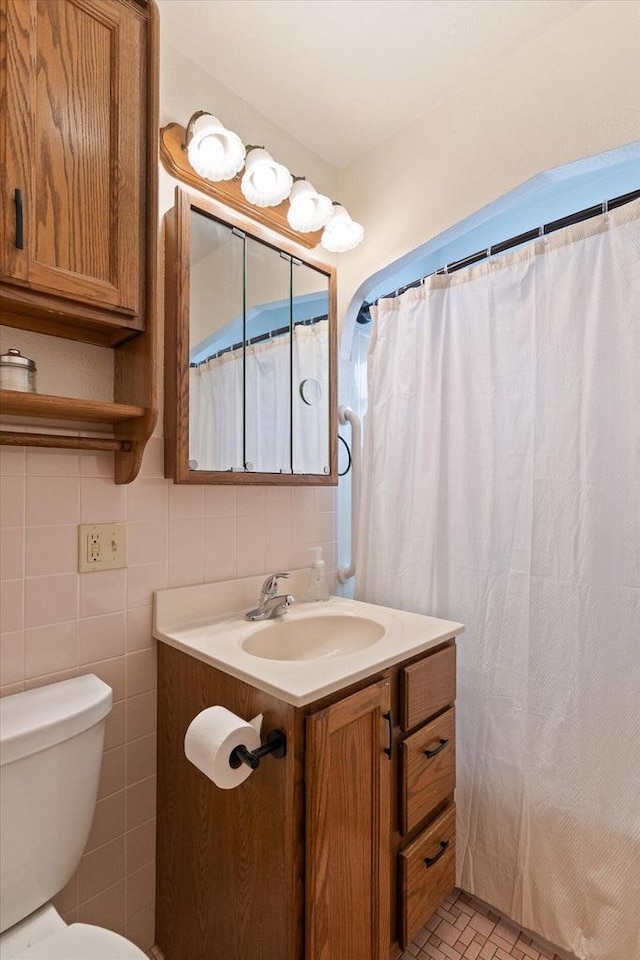 bathroom with toilet, tile walls, walk in shower, and vanity