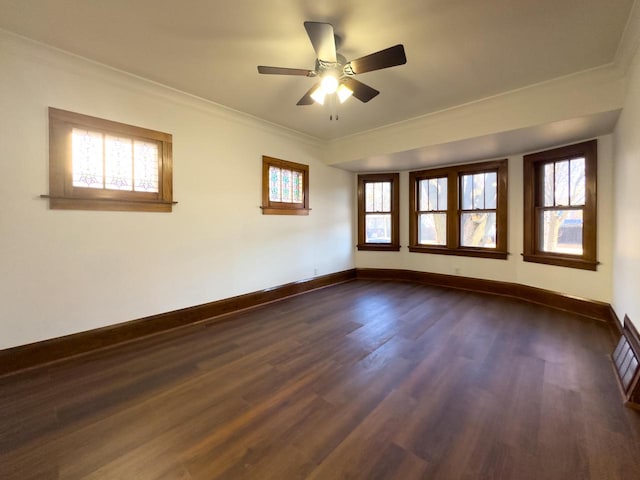 unfurnished room featuring ornamental molding, plenty of natural light, dark hardwood / wood-style floors, and ceiling fan