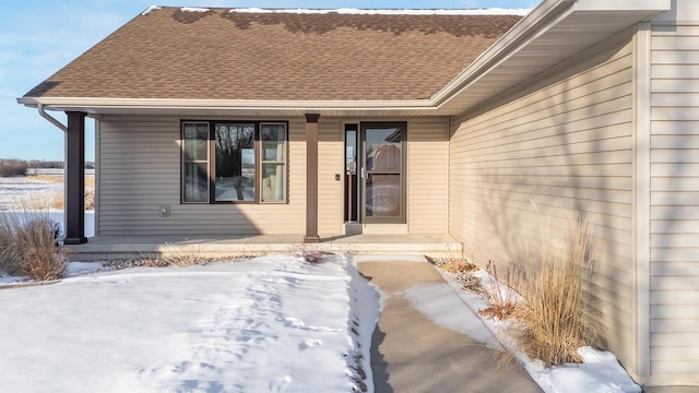 snow covered property entrance featuring a porch