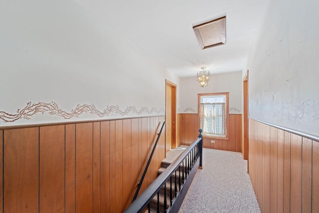 hall with carpet flooring and wood walls