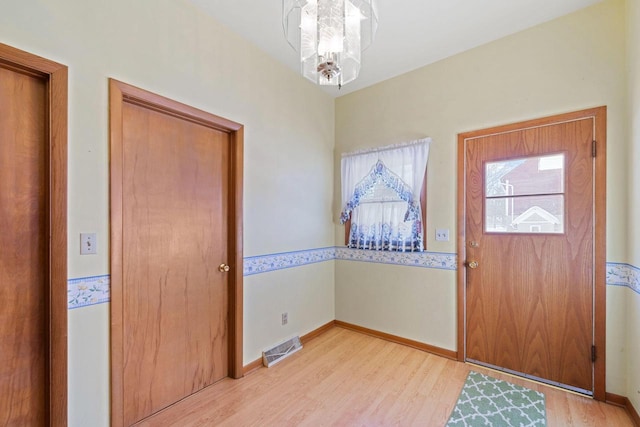 foyer featuring light hardwood / wood-style floors and a notable chandelier