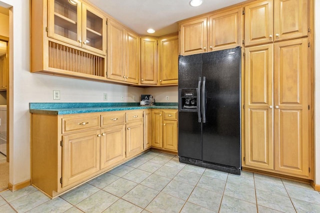 kitchen with light tile patterned flooring, black fridge with ice dispenser, and light brown cabinets