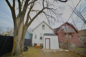 rear view of property with a storage unit